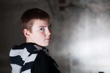 Boy looking over the shoulder against grunge background with copy space, neutral emotion check more of the same modelの写真素材