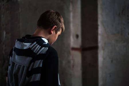 Portrait of Young teenaiger in despair against grunge background 4 light sourcesの写真素材