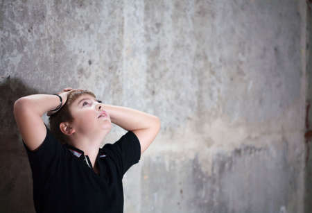 Young boy looking up with hope in his eyes against grunge background flash lit 3 light sourcesの写真素材
