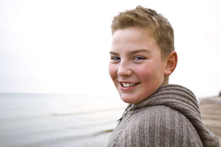 Teenager boy looking at camera in cold weather with sveater look for more o the same modelの写真素材