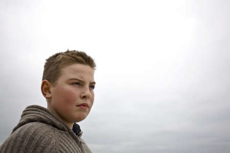 Teenager boy looking away from camera in cold weather with sveater look for more o the same modelの写真素材