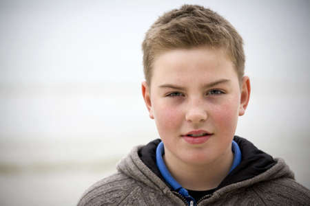 Teenager boy looking at camera in cold weather with sveater look for more o the same modelの写真素材