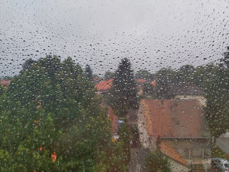 city rooftops photographed through a rainy windowの写真素材