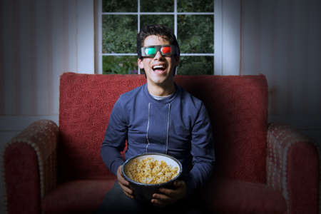 Young adult watching a 3d movie at homeの写真素材