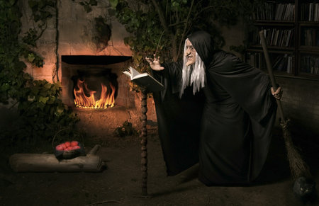 Halloween witch with her magic book casting a spell 