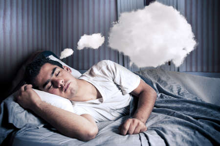 Man comfortably sleeping in his bed at nightの写真素材