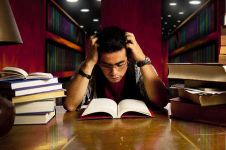 young and concentrated student reads a bookの写真素材