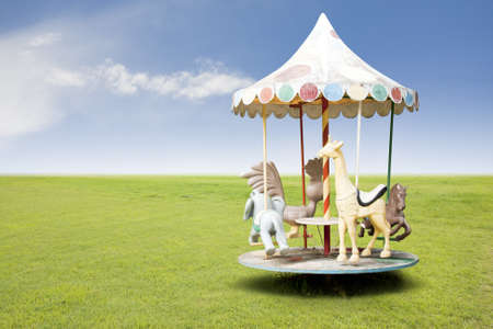 photo of a carousel for kids on grass fieldの写真素材