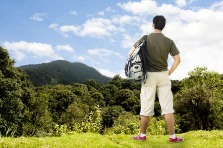 photo of a tourist atop beautiful mountain contemplating the viewの写真素材