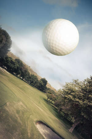 Golf ball flying over green fieldの写真素材