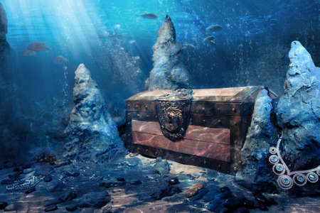 photo of wooden treasure chest submerged underwater with light raysの写真素材