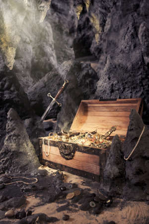 photo of open treasure chest with shinny gold in a caveの写真素材