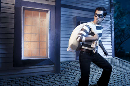 dangerous burglar about to enter houseの写真素材
