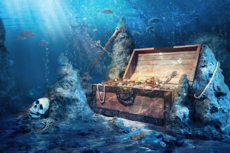 photo of open treasure chest with shinny gold underwaterの写真素材