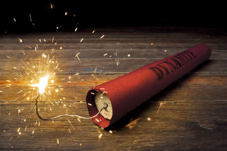 Lit dynamite stick on woodの写真素材