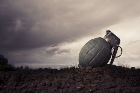 green grenade resting on a battlefieldの写真素材