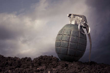 green grenade resting on a battlefieldの写真素材