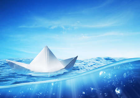 paper boat on a beautiful and vibrant seaの写真素材