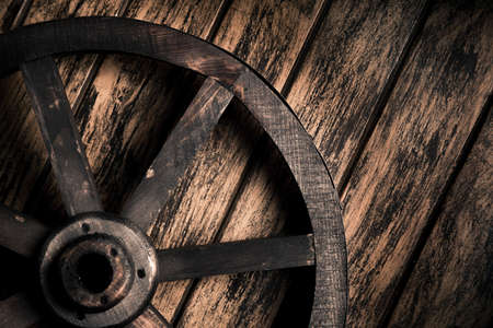 Dramatic lighting on a wood wheel on a grungy backgroundの写真素材