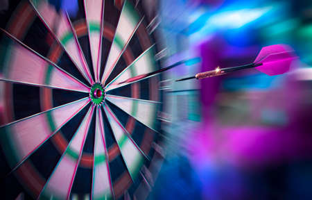 dartboard on a brick wall about to get hit by dartの写真素材