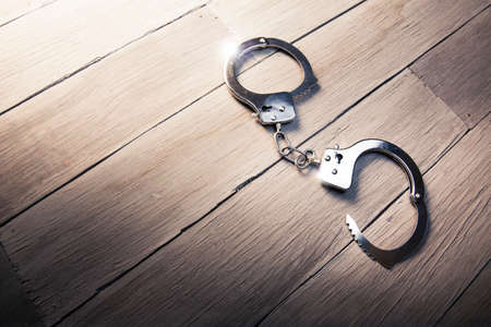 Open handcuffs, liberty concept on a wooden backgroundの写真素材