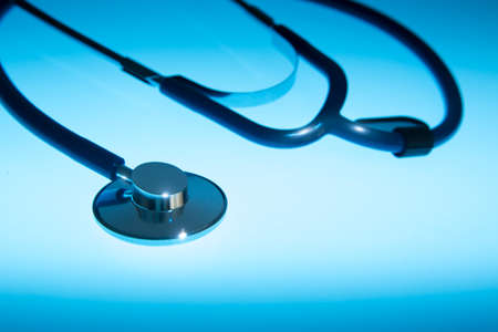 Medical Stethoscope on a blue background and dramatic lightingの写真素材