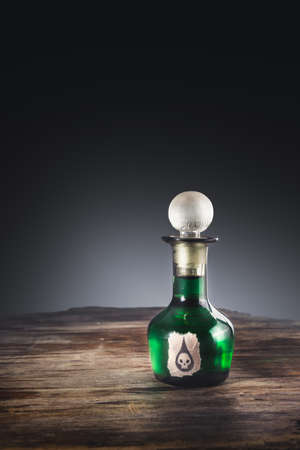 high contrast image of a poison bottle on a wooden surfaceの写真素材