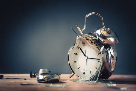 destroyed alarm clock on a wooden background