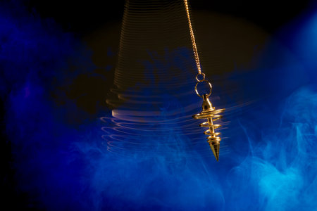 Pendulum used for hypnotism and readings swinging with motion blur