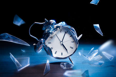 Busted alarm clock with broken glass on a dark backgroundの写真素材
