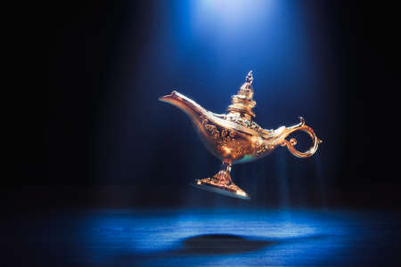 Magic genie lamp floating on a dark backgroundの写真素材