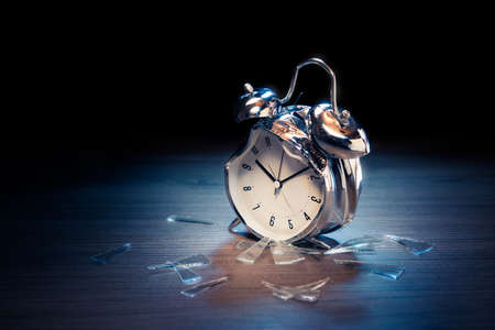 Busted alarm clock with broken glass on a dark backgroundの写真素材