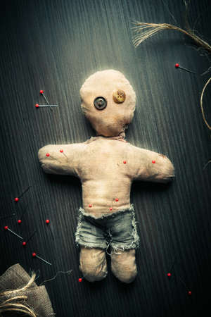 Voodoo Doll on a wooden background with dramatic lightingの素材 [FY31075333403]