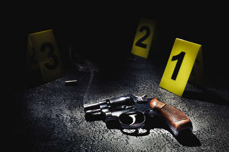 gun with smoke on the floor and evidence markers, high contrast imageの写真素材