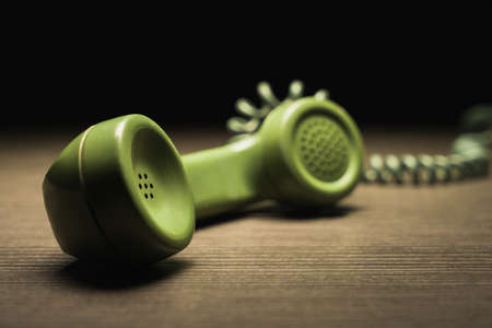 High contrast image of old rotary telephone on a wooden surface /selective focusの写真素材