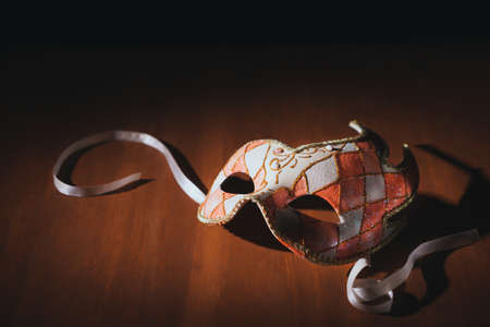Venetian carnvial mask on a wooden background / high contrast imageの写真素材