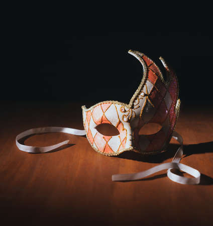 Venetian carnvial mask on a wooden background / high contrast imageの写真素材