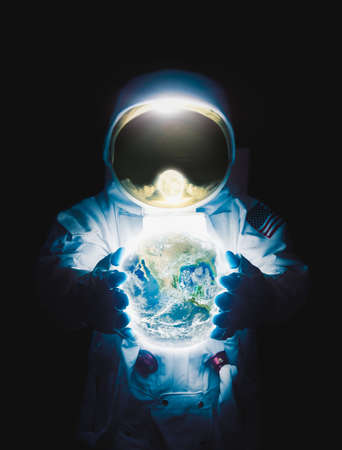 Astronaut holding planet earth/ high contrast imageの写真素材