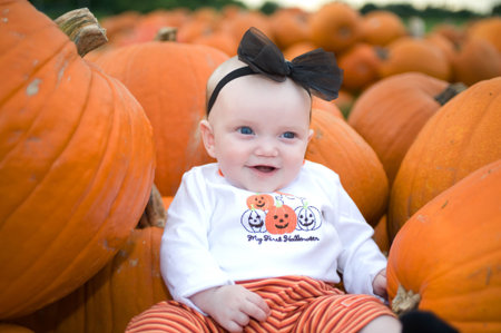Adorable baby in pumpkin patch smiling
