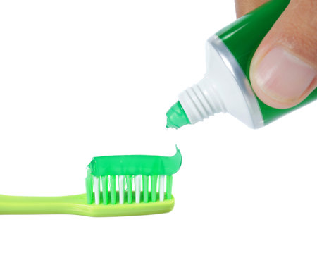 green tooth brush with green mint tooth paste on top of it