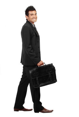 young businessman is walking and smiling to the camera. isolated over white backgroundの写真素材