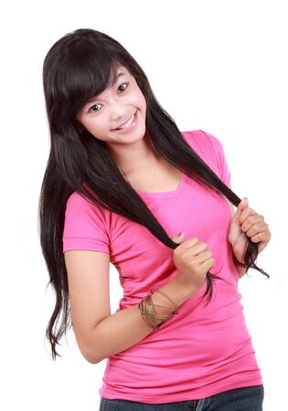 young girl smiling playing with hairの写真素材