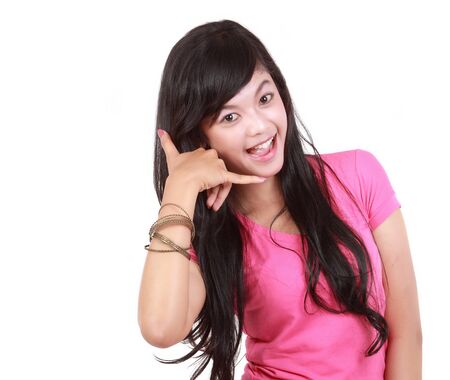 Closeup portrait of beautiful young woman making call me gesture on white backgroundの写真素材