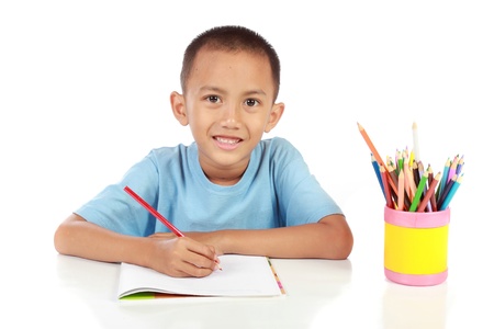 portrait of young boy studying against white backgroundの写真素材