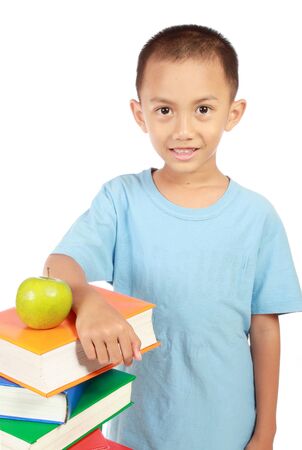 smart little boy holding many books with apple on top of it の写真素材