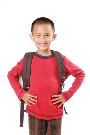 Portrait of boy with backpack smiling against white backgroundの写真素材