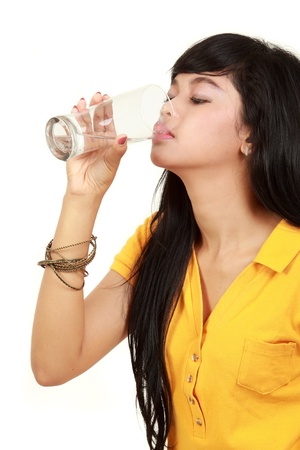 Beautiful young girl drinks water from glassの写真素材