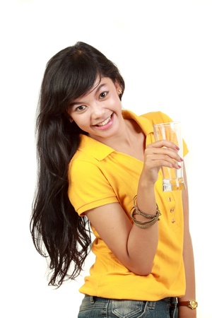portrait of young happy healthy girl holding a glass of water isolated on whiteの写真素材