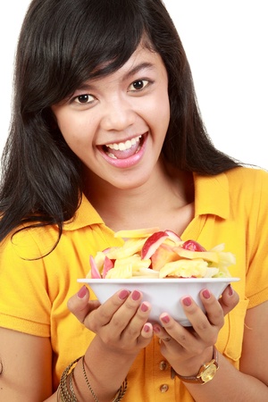 young healthy girl having a fruit salad. isolated over white backgroundの写真素材