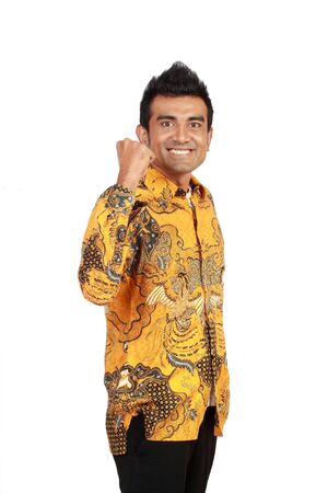 Portrait of a smiling young asian businessman standing against white backgroundの写真素材